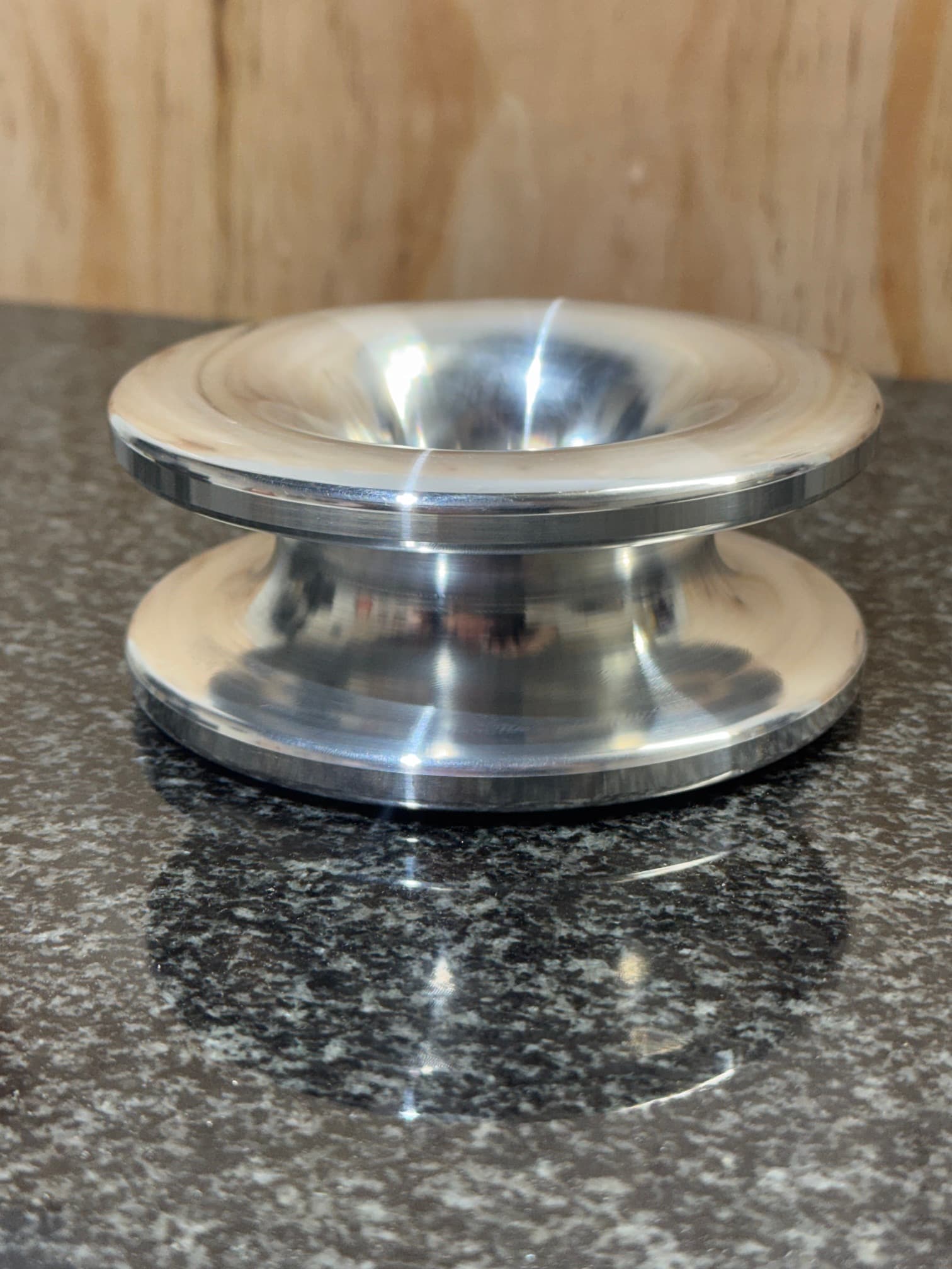 Side view of a circular machined component with a curved outer profile