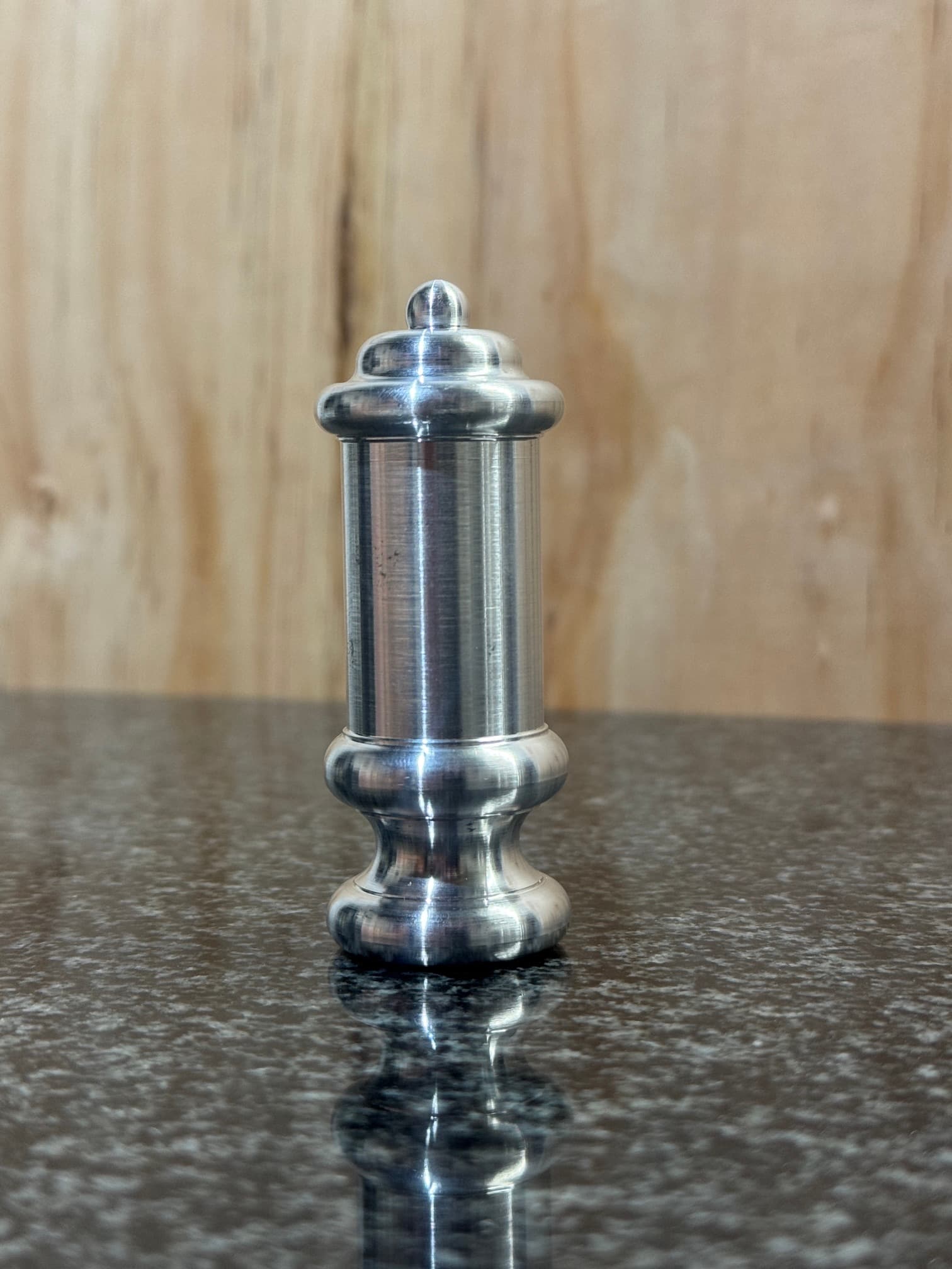Tall turned metal component with rounded shoulders and a shaped end