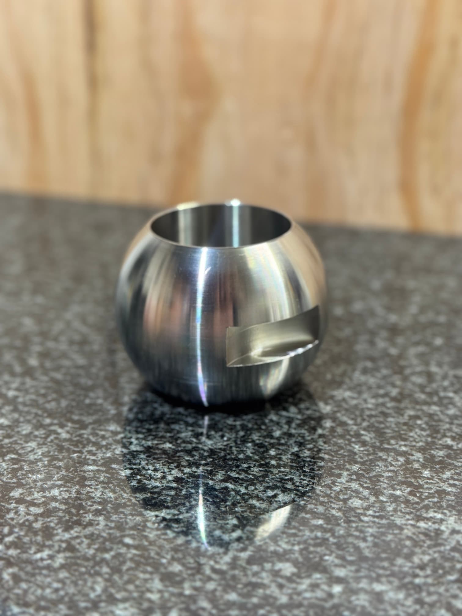 Rounded metal component with a central opening and a machined side recess