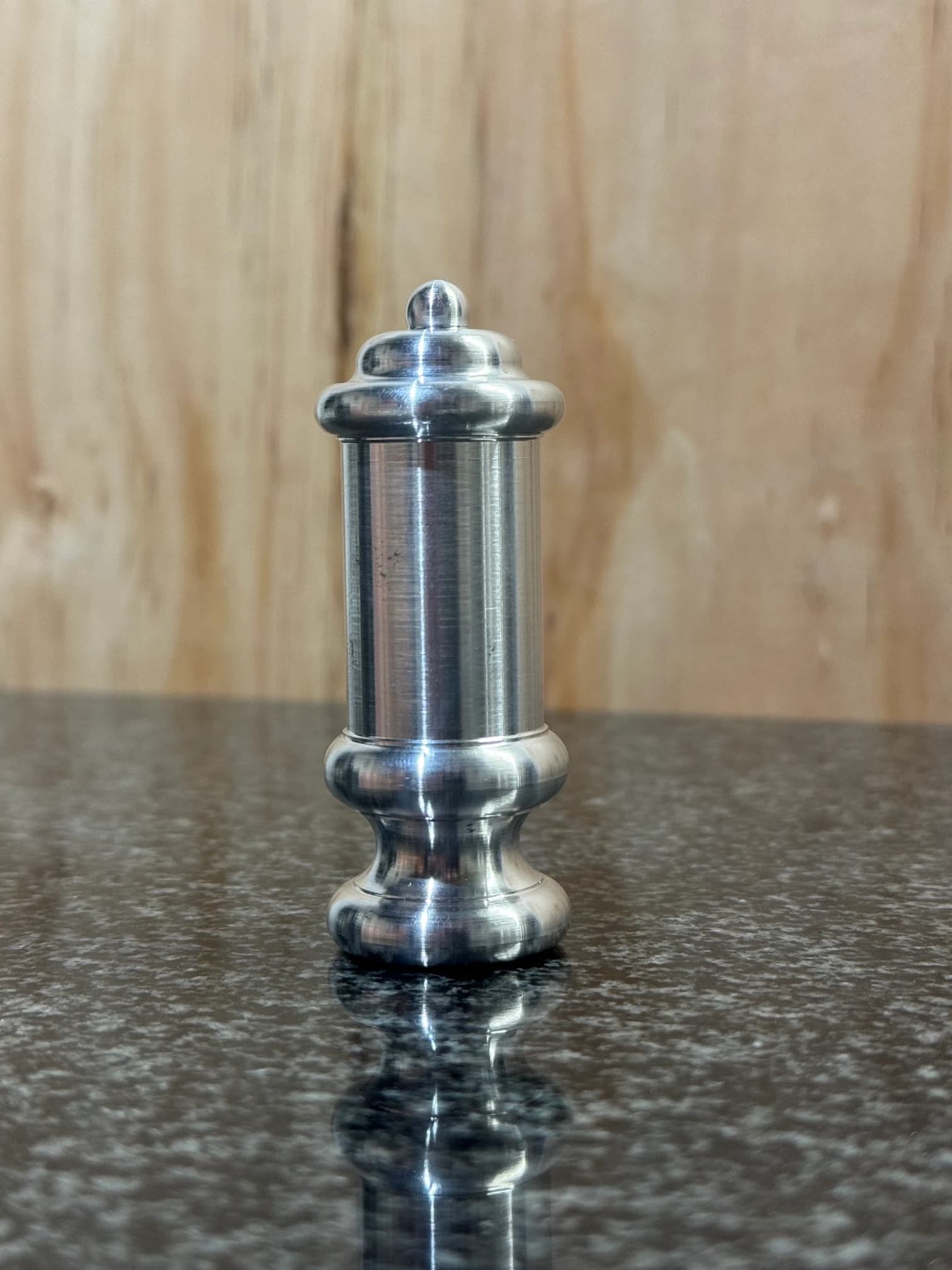 Tall turned metal component with rounded shoulders and a shaped end
